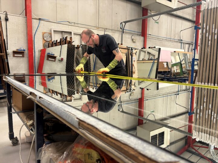 Handmade Trade Manufacturer KBB Partner Interior Door Systems Craftsman measuring mirrored wardrobe glass at Interior Door Systems, a handmade trade manufacturer and trusted KBB partner